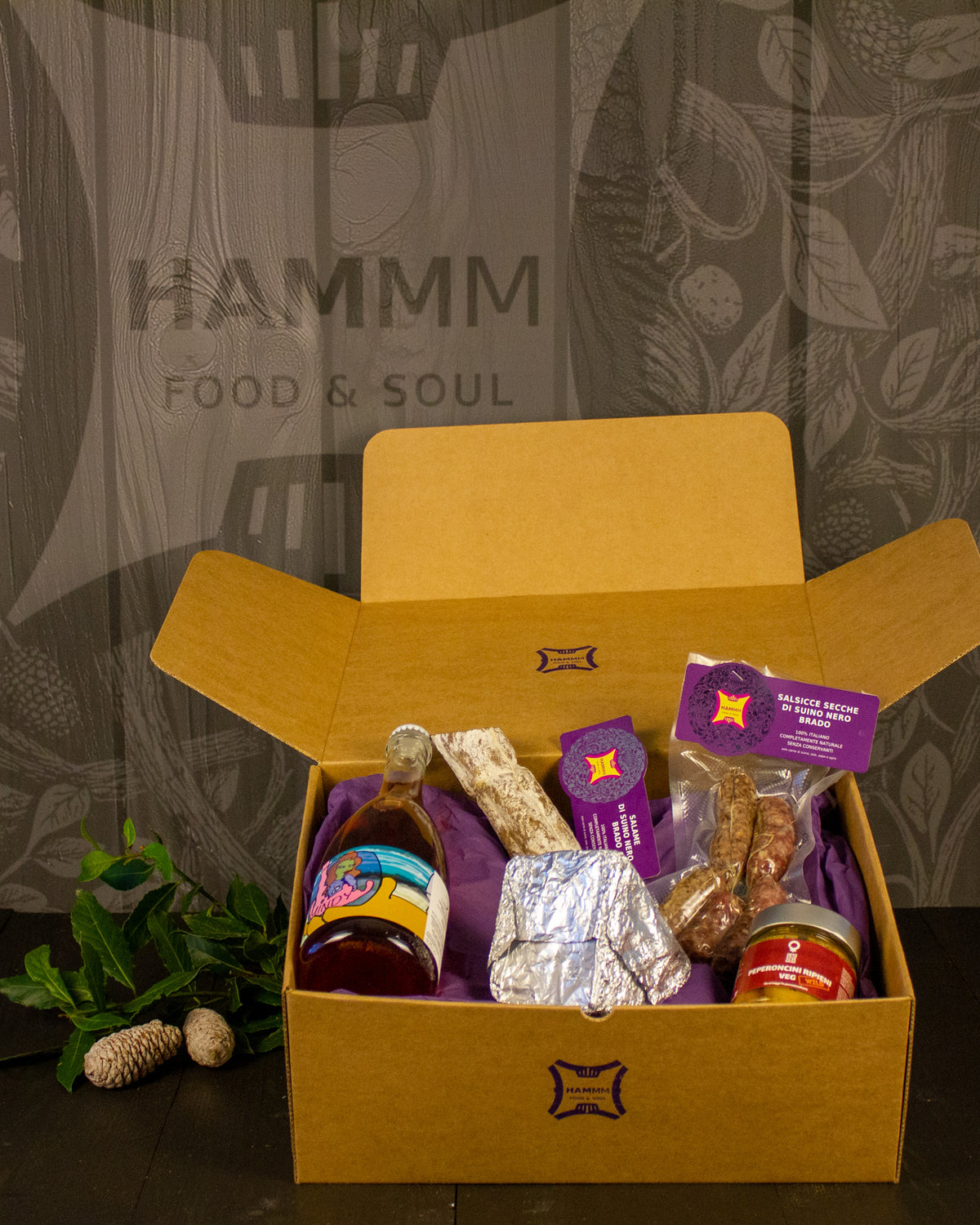 Box Natale Tagliere davanti il camino Hammm: confezione regalo aperta con i prodotti della selezione